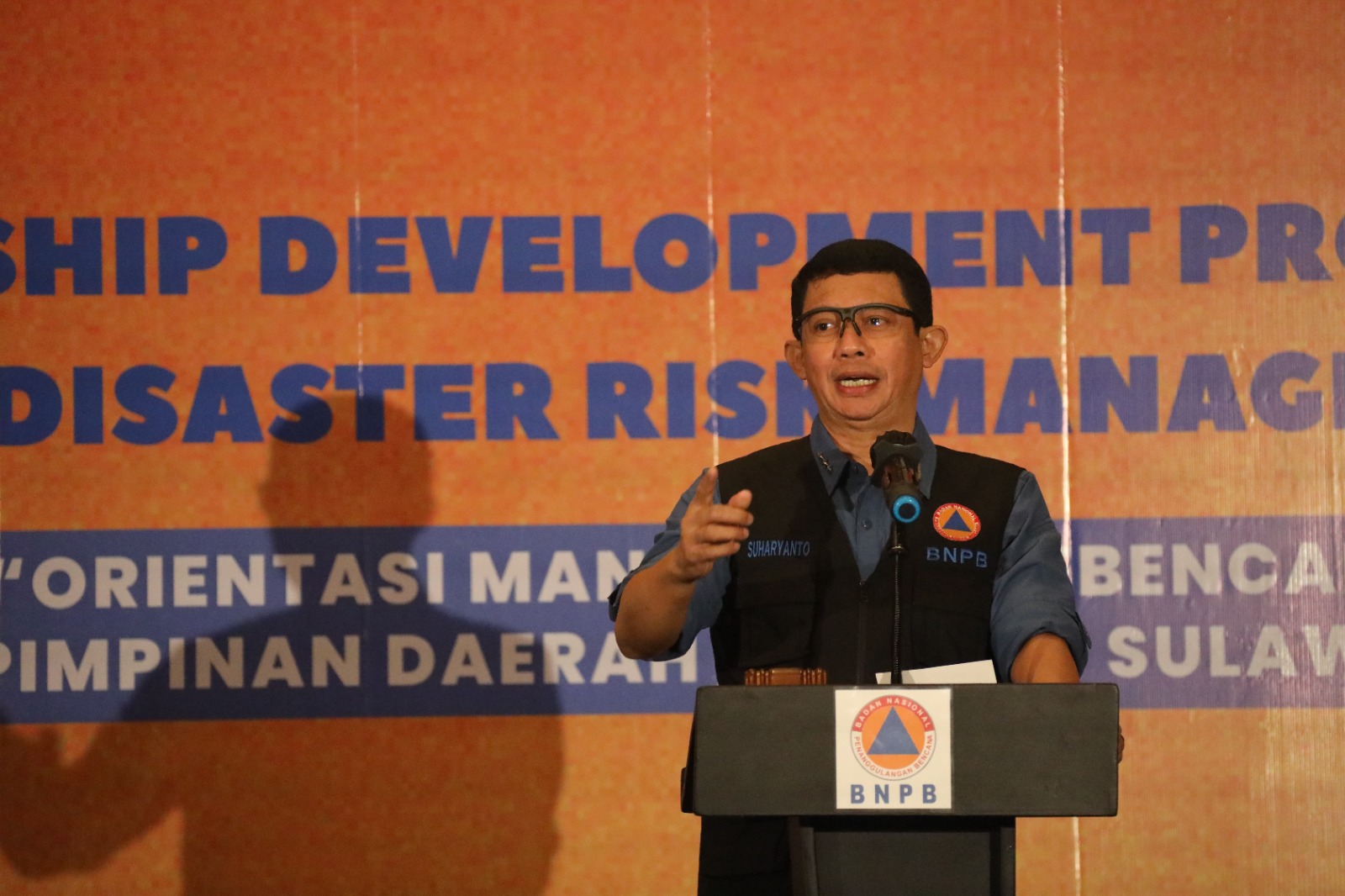 Kepala BNPB Letjen TNI Suharyanto (kemeja biru dan rompi hitam) saat memberikan paparan dalam kegiatan Orientasi Manajemen Kebencanaan Bagi Pengambil Keputusan Strategis Provinsi Sulawesi  Barat Untuk Pimpinan Daerah Provinsi Sulawesi Barat Beserta Seluruh Pimpinan Daerah Kabupaten Se-Provinsi Sulawesi Barat Tahun 2023 yang dihelat di Kabupaten Badung, Provinsi Bali pada Rabu (27/9).